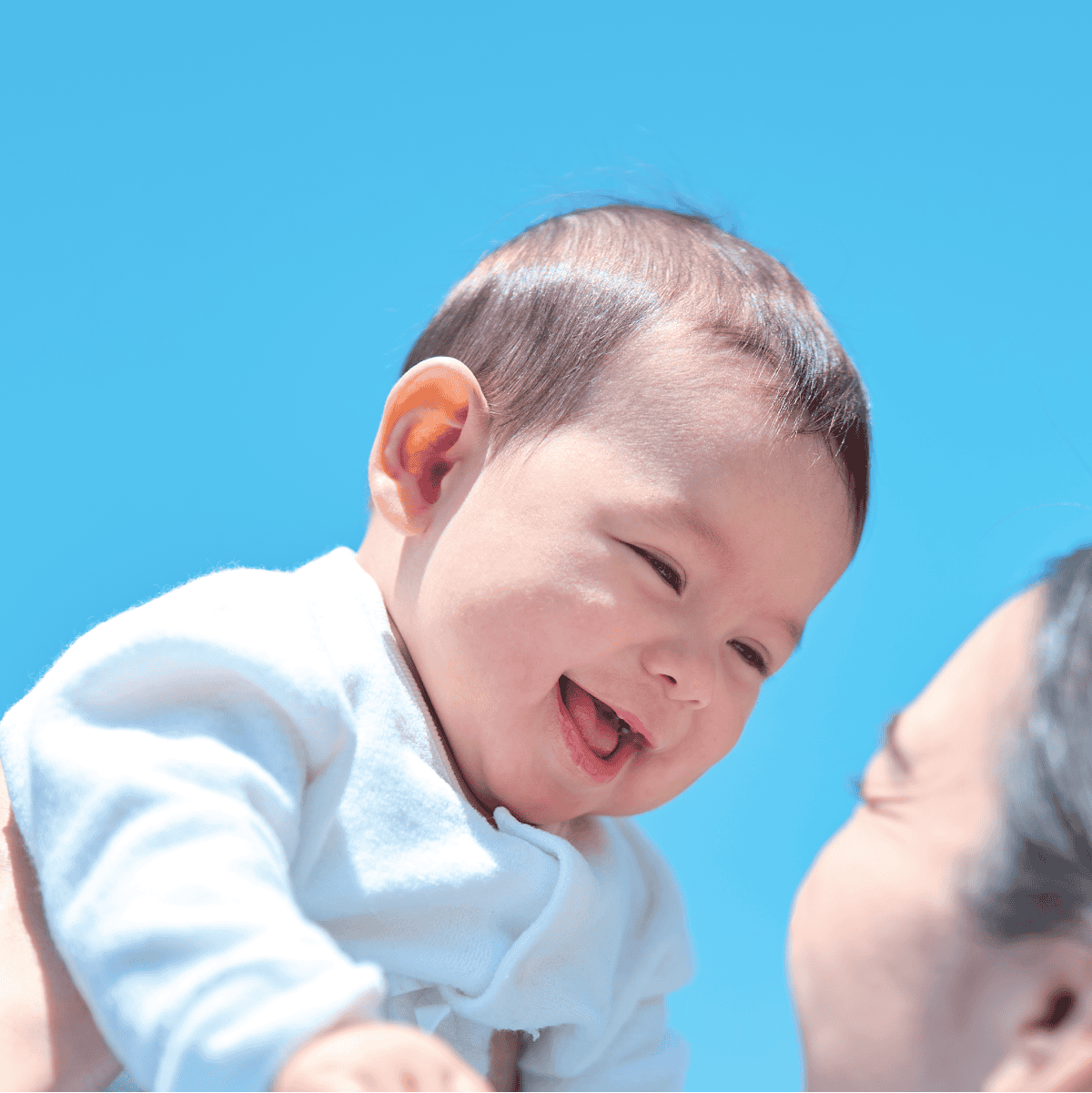 Combi Sugocal L Compact stroller feature panel showing a parent holding an infant.