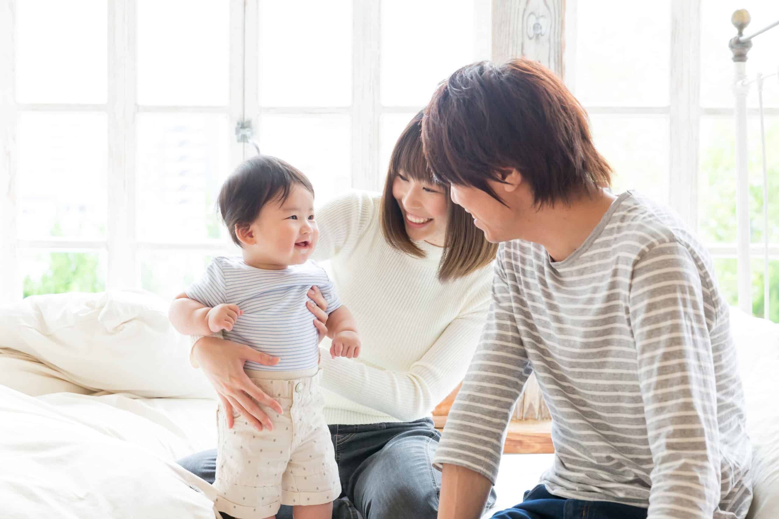 Parents smile at their infant at home.